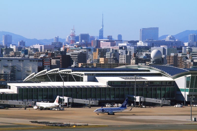 福岡空港のターミナルと駐機する旅客機、奥に福岡タワーと市街地